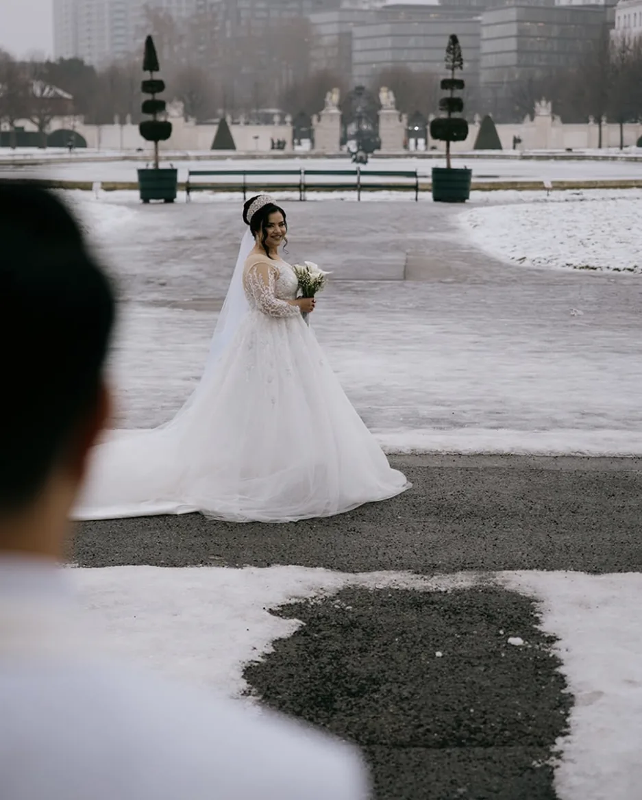 Braut im Brautkleid in einem verschneiten Schlossgarten